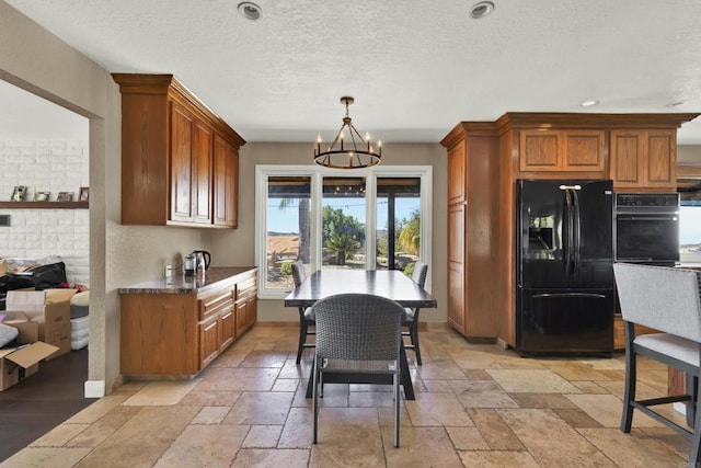 29345 Wilkes Rd, Valley Center, CA 92082 - kitchen featuring black appliances, a chandelier, stone tile floors, brown cabinetry, and a textured ceiling