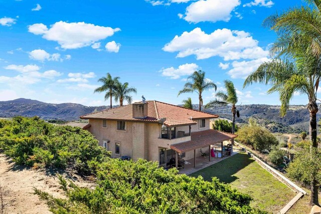 29345 Wilkes Rd, Valley Center, CA 92082 - rear view of house featuring a tiled roof, a patio, stucco siding, and a mountain view