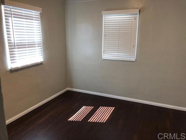 unfurnished room featuring baseboards and wood finished floors