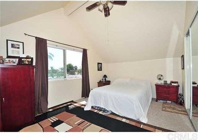 bedroom with lofted ceiling with beams and a ceiling fan