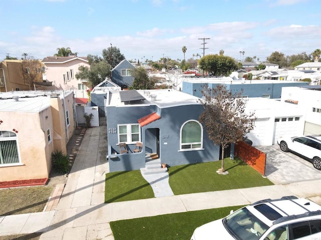 view of front of house featuring stucco siding, an attached garage, fence, driveway, and a front lawn