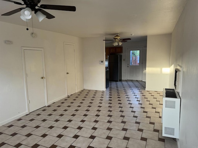 interior space featuring heating unit, ceiling fan, baseboards, and radiator heating unit