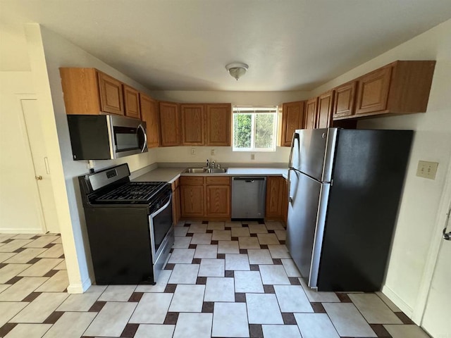 kitchen featuring stainless steel appliances, a sink, and light countertops