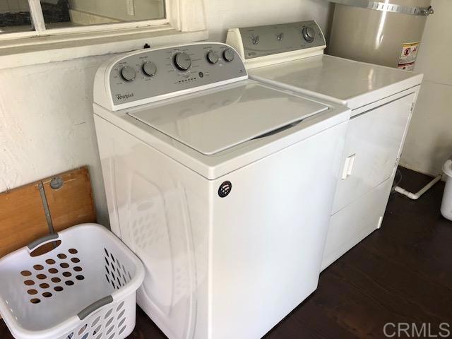 laundry area featuring dark wood-style floors, laundry area, and washer and clothes dryer