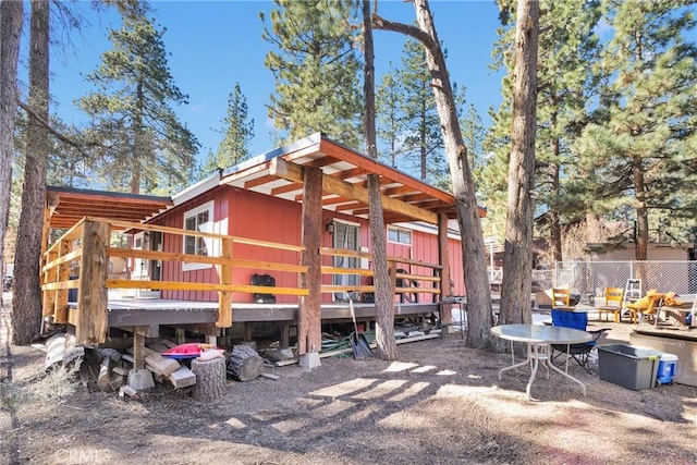 rear view of property featuring fence and a deck