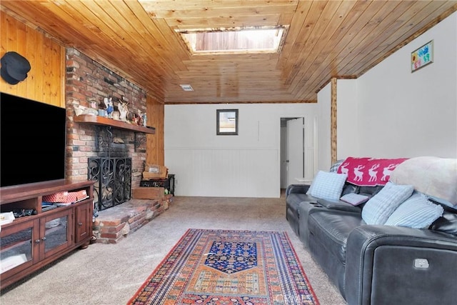 living area with carpet, vaulted ceiling with skylight, wooden ceiling, and a fireplace