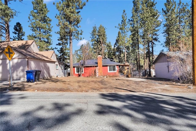 view of front of house featuring driveway and a chimney