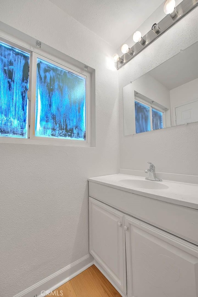 bathroom featuring a textured wall, wood finished floors, and vanity