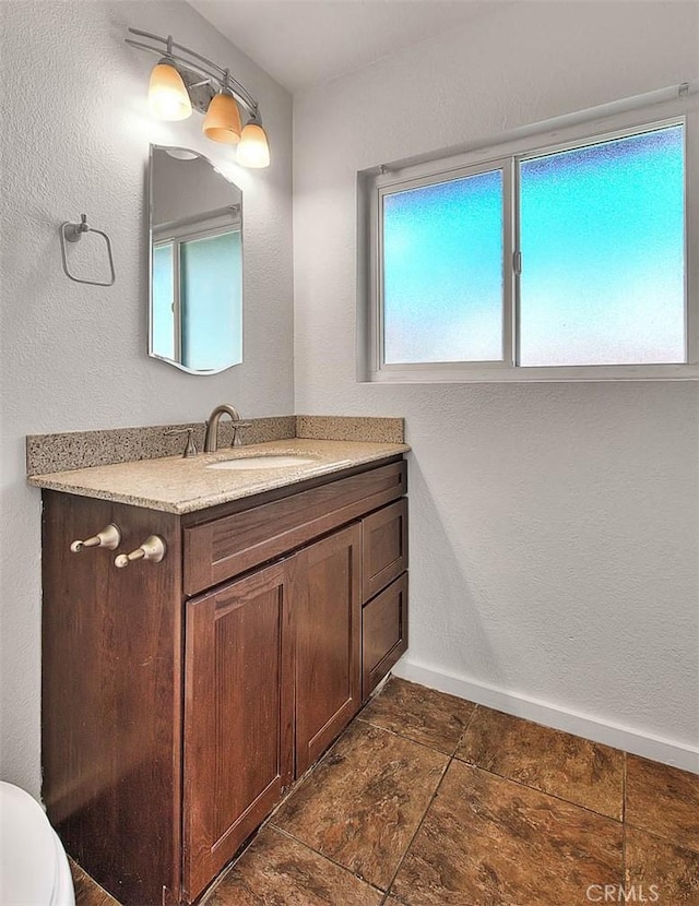 bathroom featuring baseboards and vanity