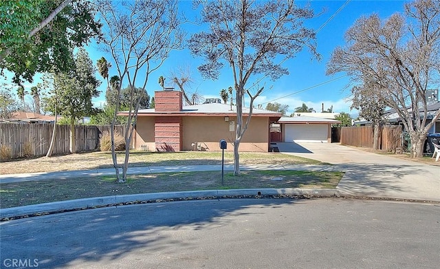 view of front facade featuring an outbuilding, a chimney, stucco siding, fence, and a garage