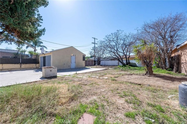 view of yard featuring a patio area, a fenced backyard, and an outdoor structure