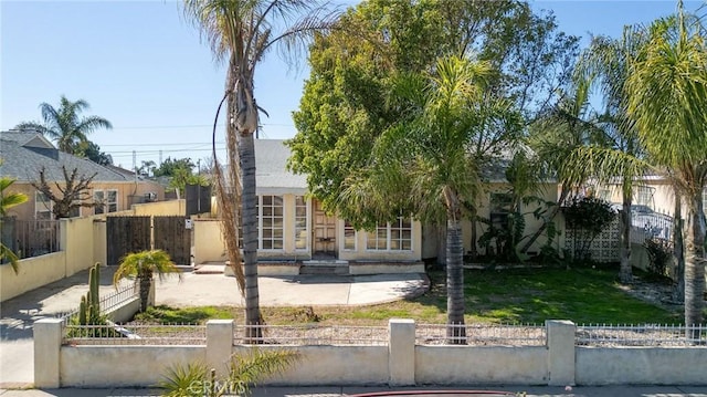 view of front facade featuring a fenced front yard and stucco siding