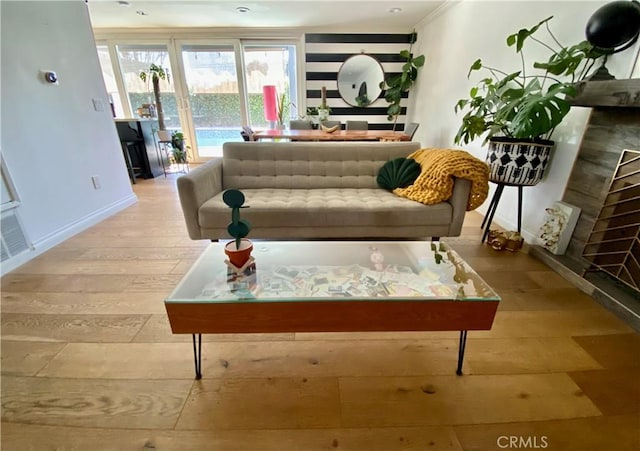 interior space with light wood-style floors, visible vents, a fireplace, and baseboards