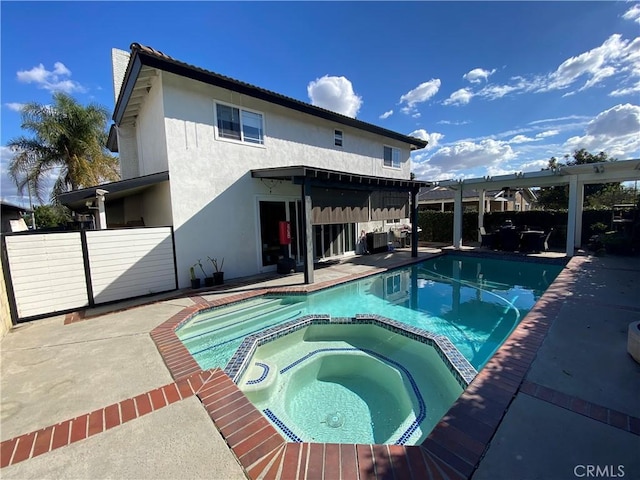 view of pool featuring a patio area, fence, a pool with connected hot tub, and a pergola