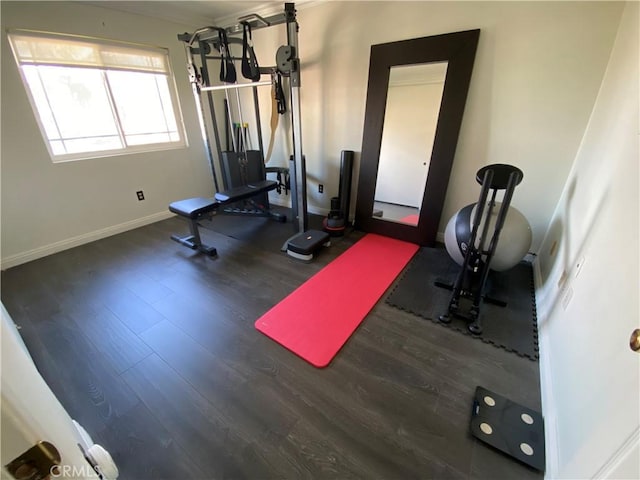 exercise area with baseboards and dark wood finished floors