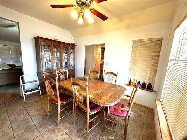 tiled dining space featuring lofted ceiling and a ceiling fan