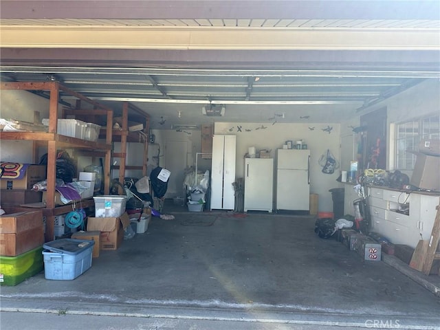 garage featuring a garage door opener and freestanding refrigerator