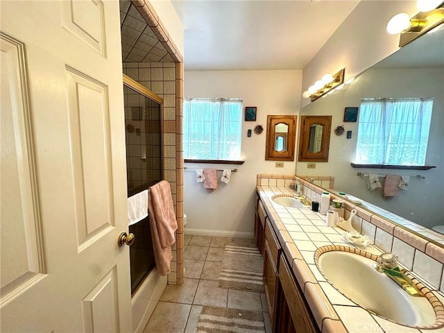 full bath with double vanity, tile patterned flooring, baseboards, and a sink