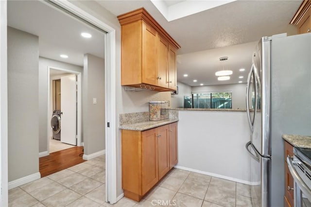 kitchen featuring baseboards, washer / dryer, light tile patterned flooring, recessed lighting, and appliances with stainless steel finishes