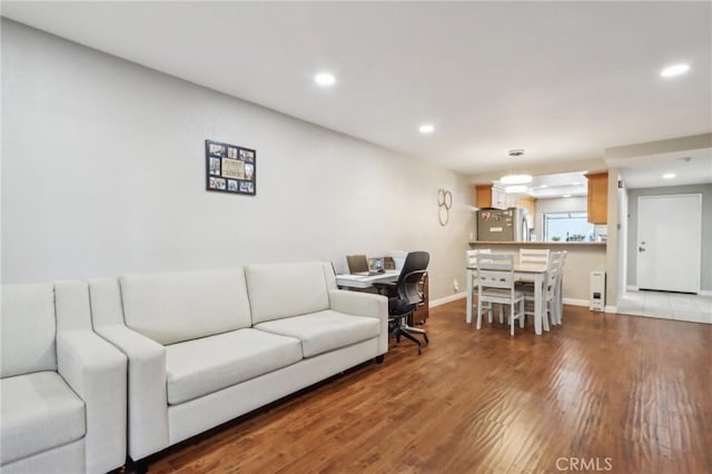 living room featuring recessed lighting, baseboards, and wood finished floors