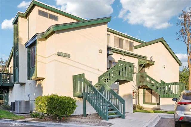 view of property with stairway and central air condition unit