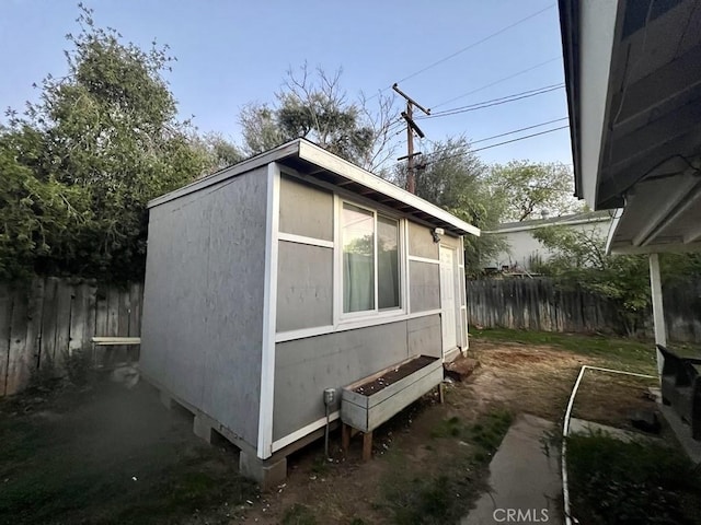 view of side of home with fence and an outdoor structure