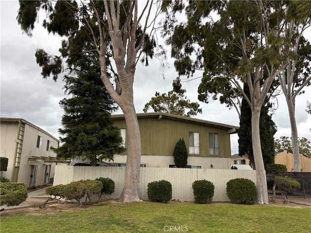 view of home's exterior featuring a lawn and fence