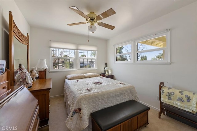 bedroom with ceiling fan, baseboards, and light colored carpet