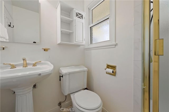 bathroom with toilet and baseboards