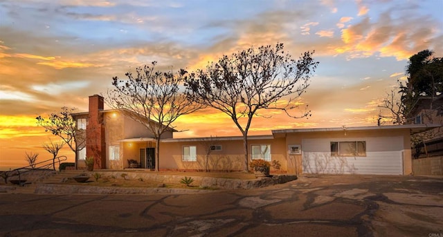 back of property at dusk with stucco siding