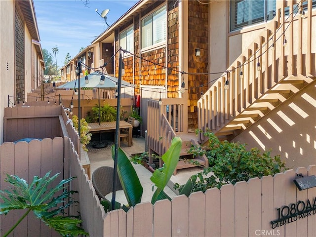 exterior space with stairs, a fenced backyard, and stucco siding