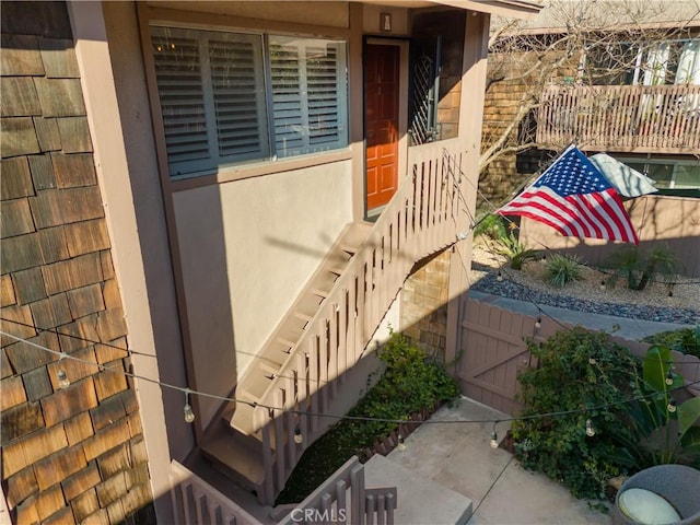 entrance to property with fence and stucco siding