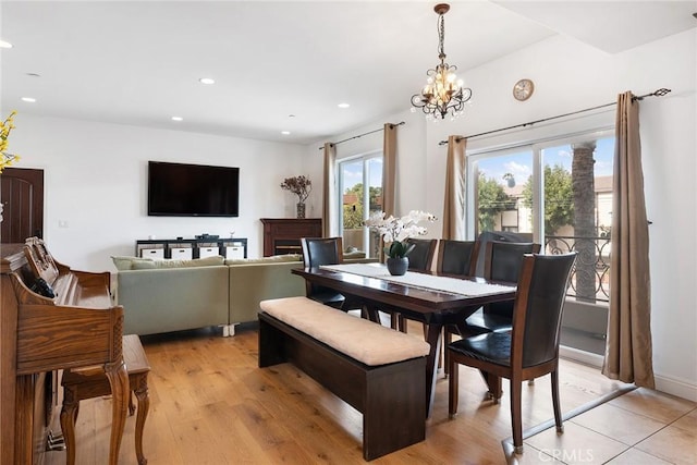 dining area featuring light wood-type flooring, a notable chandelier, and recessed lighting