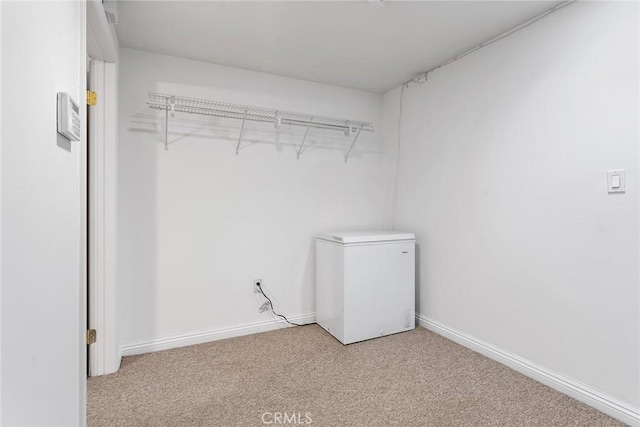 laundry room with baseboards and light colored carpet