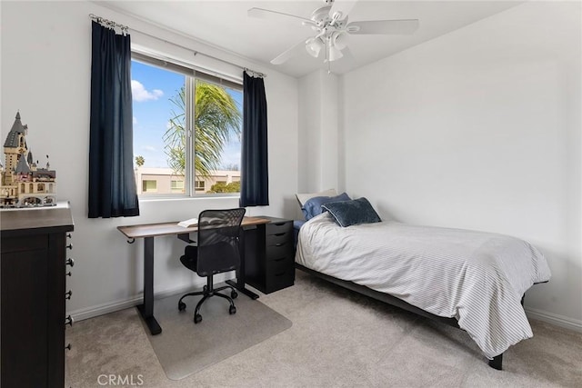 bedroom featuring a ceiling fan, light carpet, and baseboards