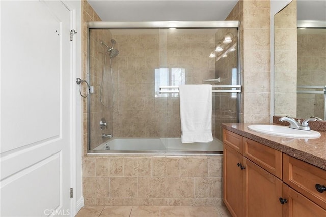 bathroom featuring tiled shower / bath combo, tile patterned flooring, and vanity