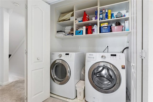 clothes washing area featuring laundry area, light carpet, and washing machine and clothes dryer