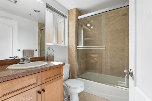 bathroom featuring visible vents, toilet, enclosed tub / shower combo, vanity, and tile patterned flooring