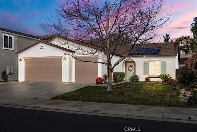 view of front facade featuring concrete driveway, stucco siding, a tile roof, an attached garage, and a front yard