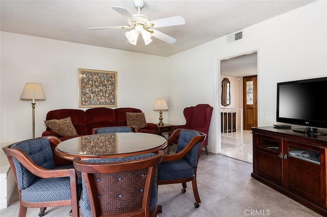 interior space with light tile patterned floors, ceiling fan, visible vents, and a textured ceiling