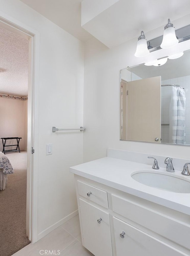 full bathroom with a shower with curtain, vanity, a textured ceiling, tile patterned flooring, and baseboards