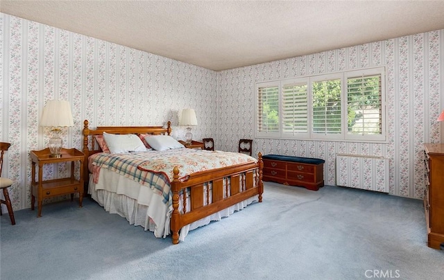 carpeted bedroom with a textured ceiling and wallpapered walls