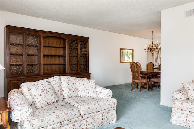 carpeted living room featuring a chandelier, a textured ceiling, and visible vents