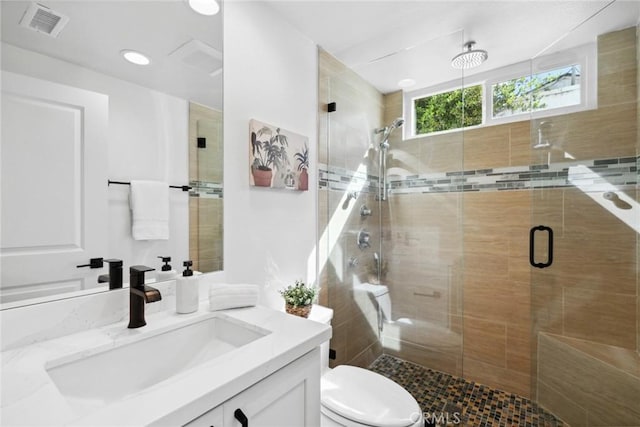 full bathroom with toilet, a stall shower, visible vents, and vanity