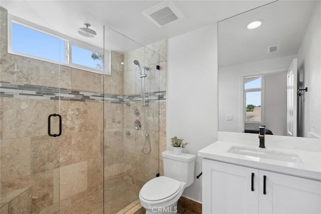 full bathroom featuring toilet, vanity, a shower stall, and visible vents