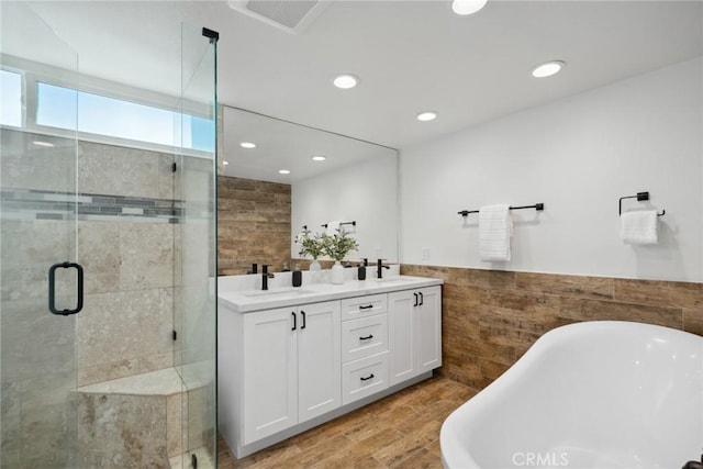 full bathroom with visible vents, a freestanding bath, a stall shower, wainscoting, and a sink