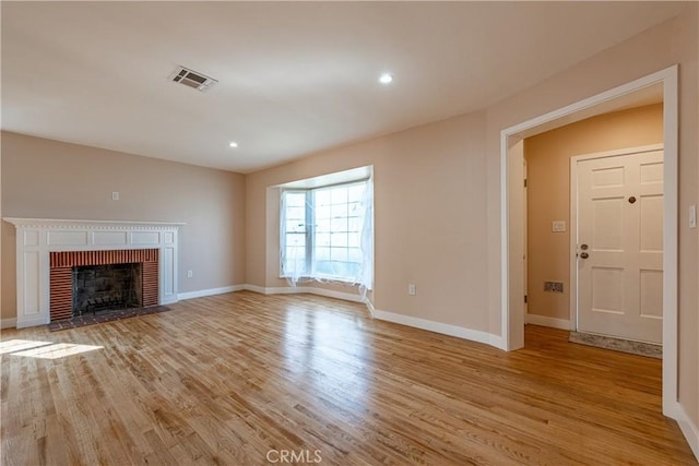 3722 Degnan Blvd, Los Angeles, CA 90018 - unfurnished living room featuring light wood finished floors, a brick fireplace, baseboards, and recessed lighting