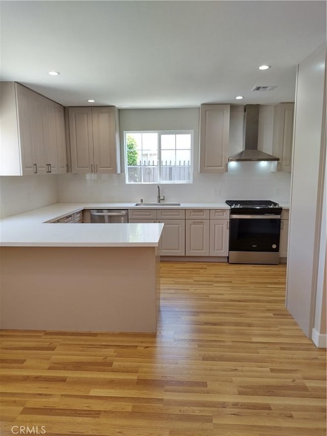 3722 Degnan Blvd, Los Angeles, CA 90018 - kitchen with wall chimney range hood, electric range, dishwasher, a sink, and light wood-style floors