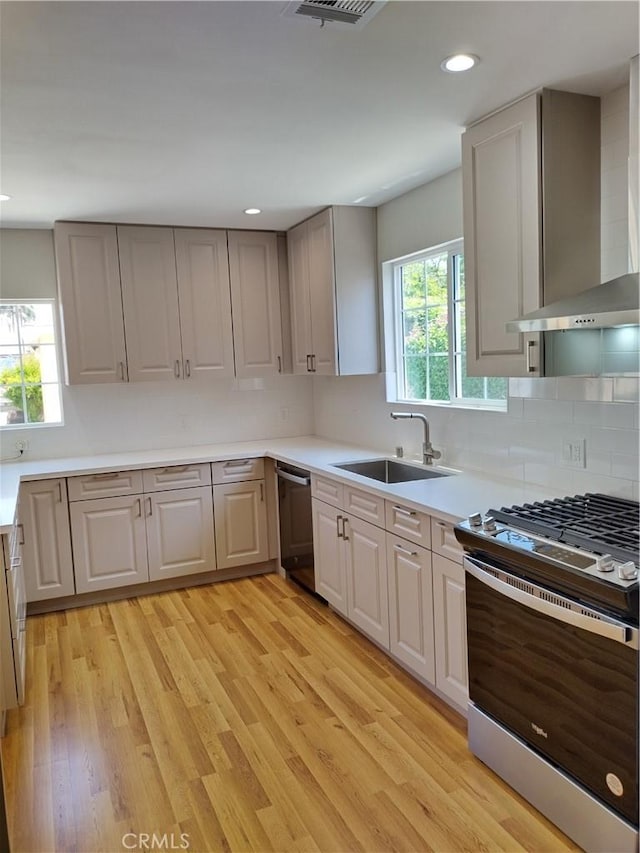 3722 Degnan Blvd, Los Angeles, CA 90018 - kitchen featuring appliances with stainless steel finishes, a sink, healthy amount of natural light, light wood-style flooring, and recessed lighting