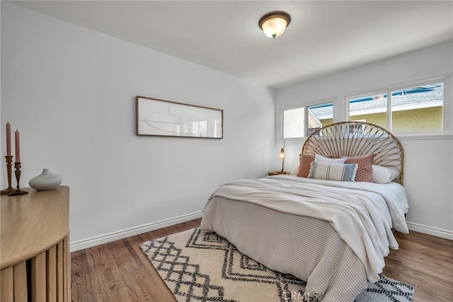 bedroom with baseboards and wood finished floors